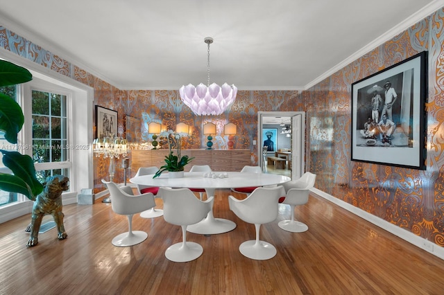 dining space with an inviting chandelier, hardwood / wood-style floors, and crown molding