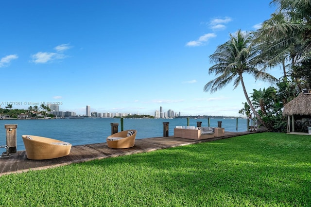 view of dock with a water view and a yard