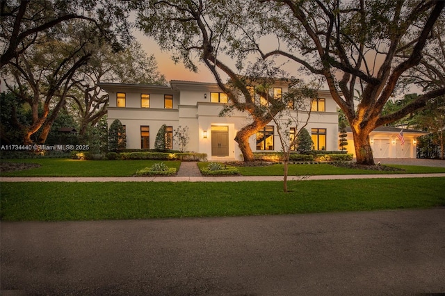 view of front of house with a garage and a lawn