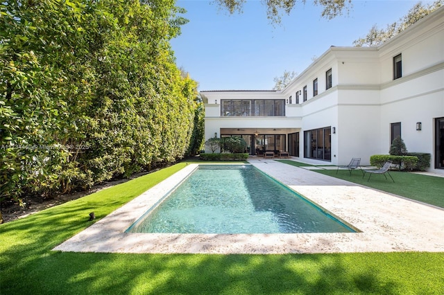 view of pool featuring a patio and a lawn