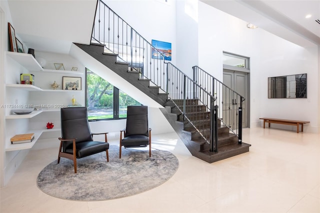 stairway featuring a towering ceiling