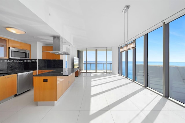 kitchen with expansive windows, appliances with stainless steel finishes, a water view, and dark countertops