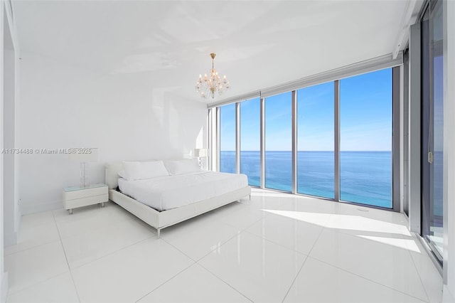 unfurnished bedroom featuring expansive windows, a water view, light tile patterned floors, and an inviting chandelier