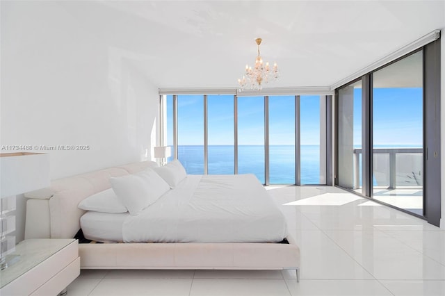 tiled bedroom featuring expansive windows, a water view, an inviting chandelier, and multiple windows