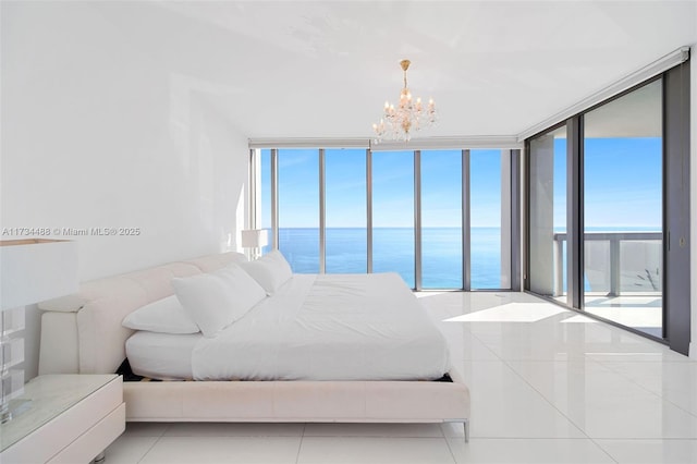 bedroom featuring a water view, multiple windows, tile patterned flooring, and a notable chandelier