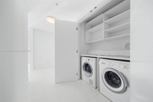 laundry area with light tile patterned flooring and washer and clothes dryer