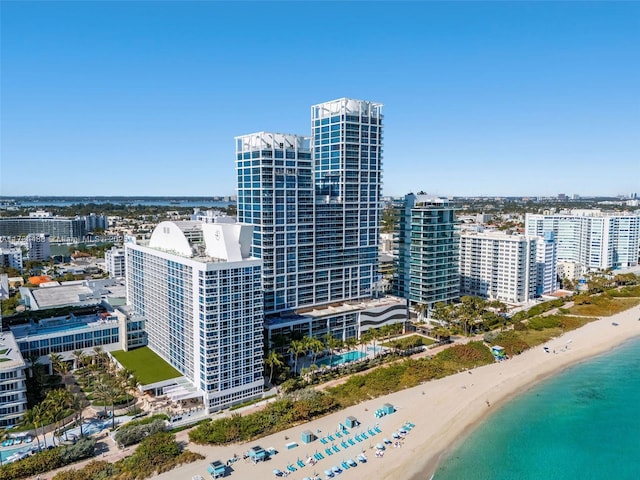 bird's eye view featuring a view of the beach, a city view, and a water view