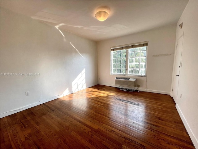 unfurnished room featuring an AC wall unit and dark hardwood / wood-style floors