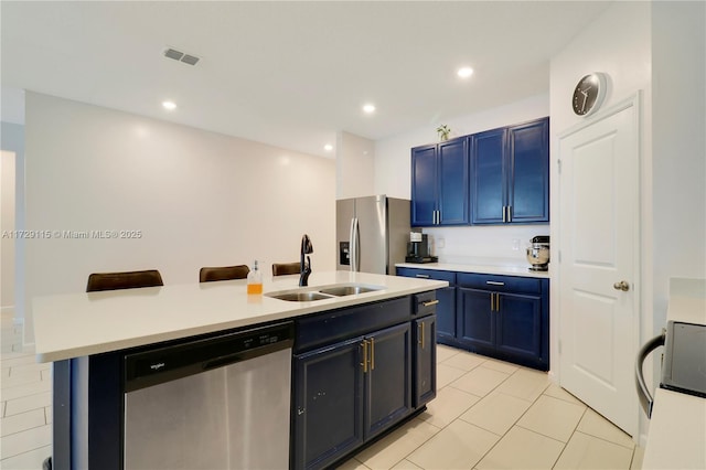 kitchen featuring appliances with stainless steel finishes, blue cabinets, sink, and a breakfast bar area