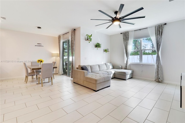 living room featuring light tile patterned floors and ceiling fan