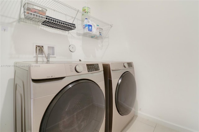 laundry area featuring light tile patterned floors and washer and dryer