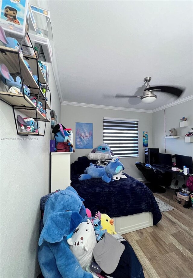 bedroom featuring hardwood / wood-style flooring, ceiling fan, and crown molding