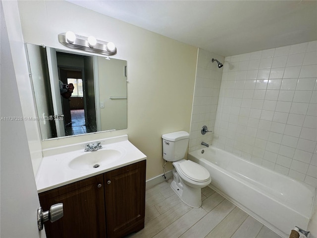 full bathroom featuring tiled shower / bath combo, vanity, hardwood / wood-style flooring, and toilet