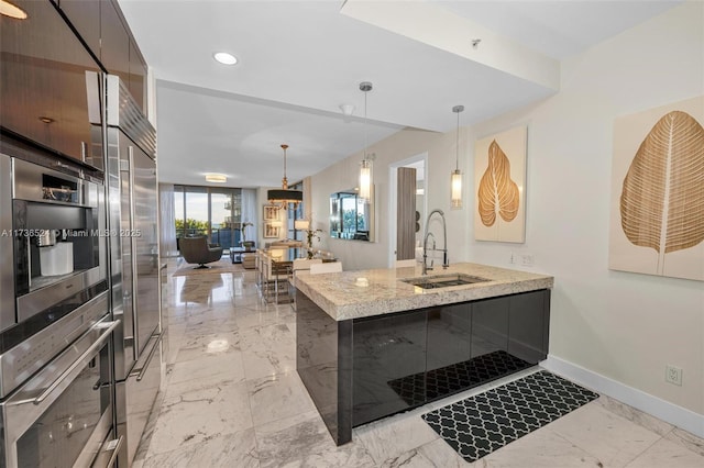 kitchen featuring pendant lighting, sink, oven, light stone counters, and kitchen peninsula