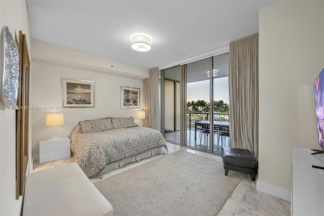 bedroom featuring a wall of windows and access to outside