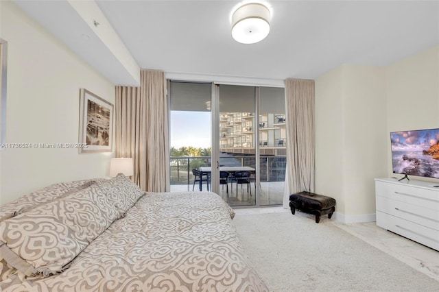 bedroom featuring expansive windows and access to outside