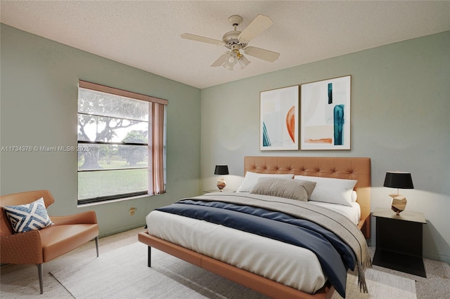 carpeted bedroom with ceiling fan and a textured ceiling