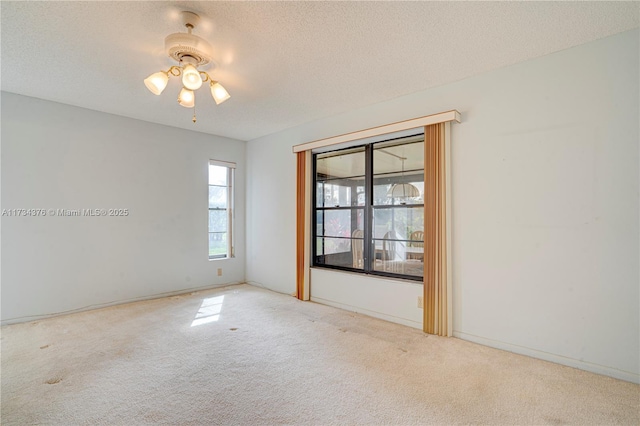 unfurnished room with ceiling fan, light colored carpet, and a textured ceiling