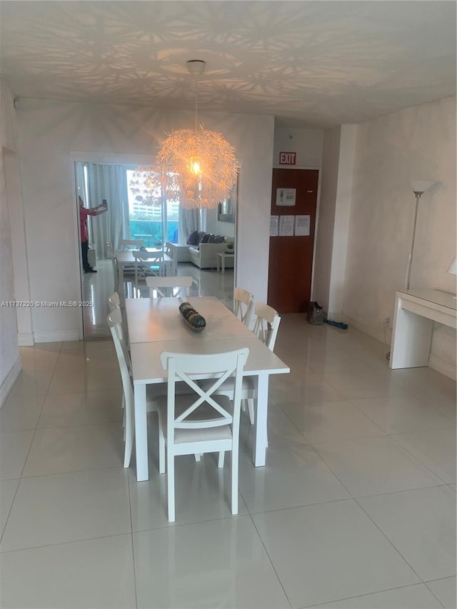 tiled dining room with a chandelier