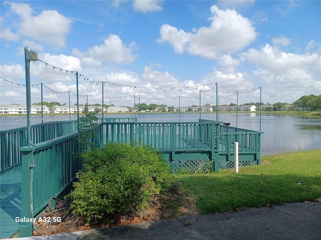 view of pool with a deck with water view and a yard