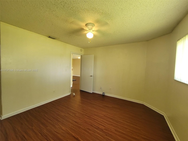 empty room featuring dark hardwood / wood-style floors and a textured ceiling