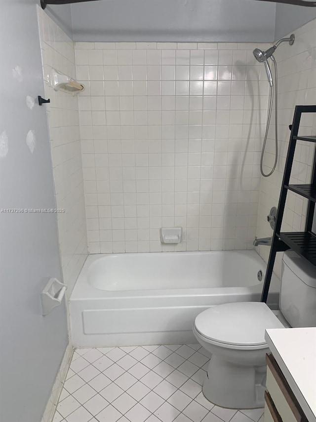 full bathroom featuring tiled shower / bath combo, vanity, tile patterned floors, and toilet