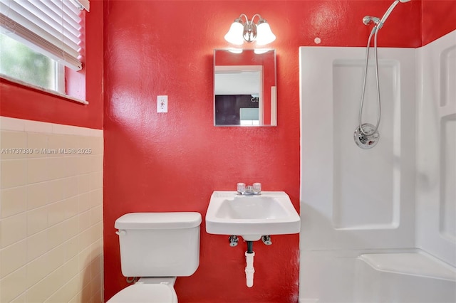 bathroom with walk in shower, toilet, and sink