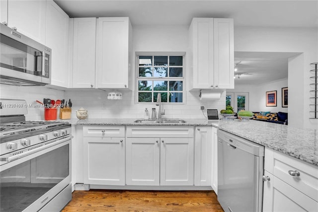 kitchen featuring white cabinetry, sink, decorative backsplash, and appliances with stainless steel finishes