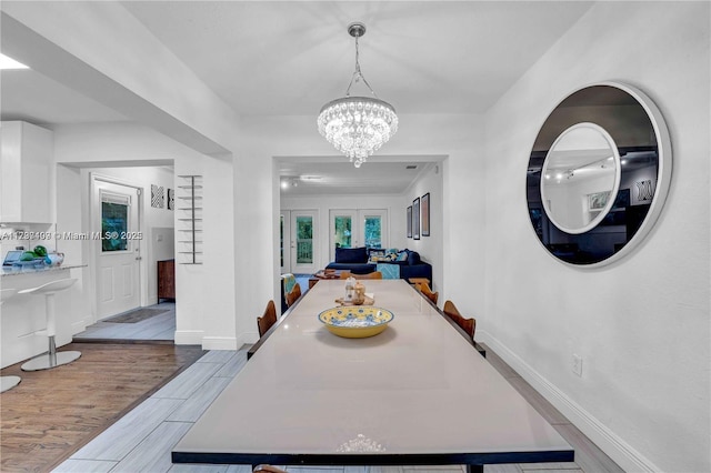 dining room with an inviting chandelier and french doors