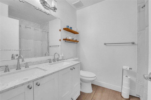 bathroom with vanity, hardwood / wood-style flooring, and toilet