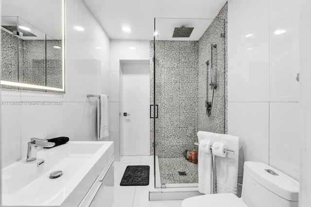 bathroom featuring tile walls, toilet, and a shower stall