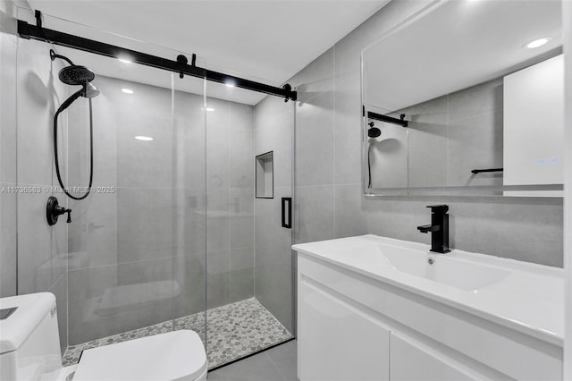 full bathroom with toilet, tile walls, a shower stall, tile patterned flooring, and vanity