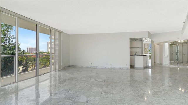 unfurnished room featuring a wall of windows