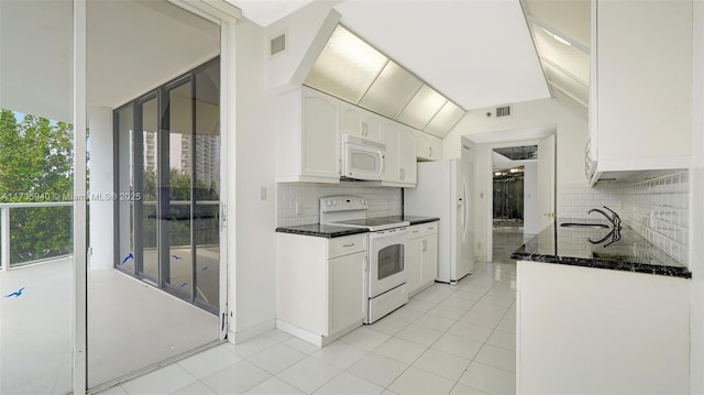 kitchen featuring tasteful backsplash, white appliances, vaulted ceiling, light tile patterned floors, and white cabinetry