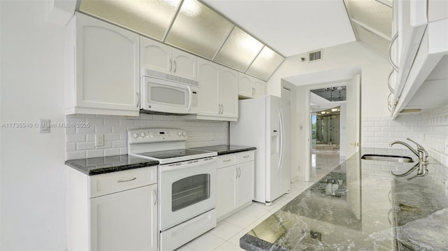 kitchen with white appliances, dark stone countertops, sink, and white cabinets