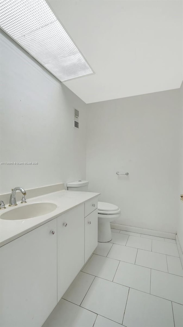 bathroom featuring vanity, toilet, and tile patterned floors