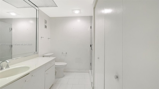 bathroom with vanity, tile patterned flooring, toilet, and walk in shower