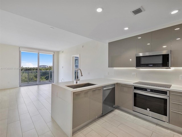 kitchen featuring stainless steel appliances, sink, gray cabinetry, and kitchen peninsula