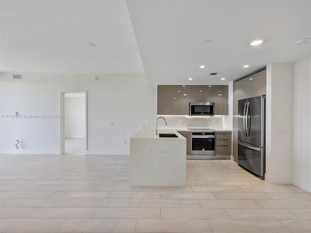 kitchen featuring appliances with stainless steel finishes, sink, gray cabinetry, and kitchen peninsula