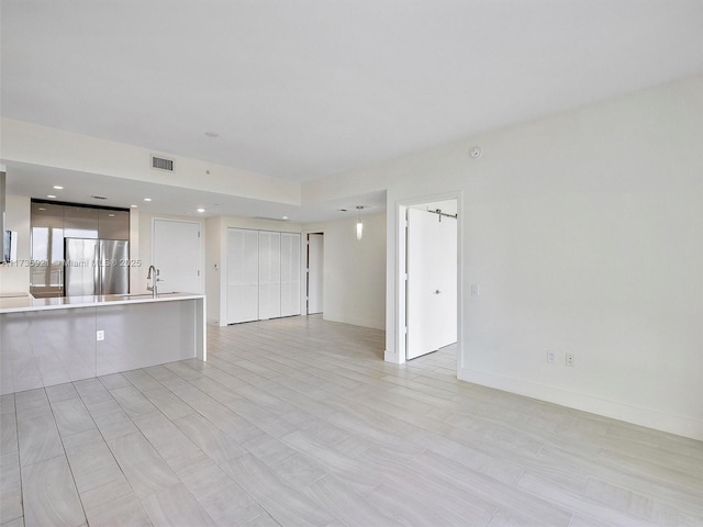 unfurnished living room featuring sink