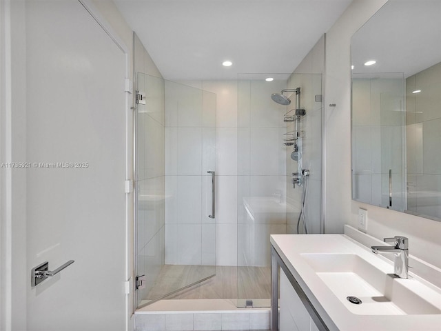 bathroom with a shower with door and vanity