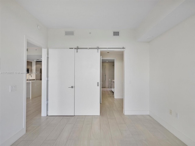 unfurnished bedroom with a barn door