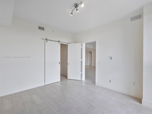 unfurnished room featuring a barn door