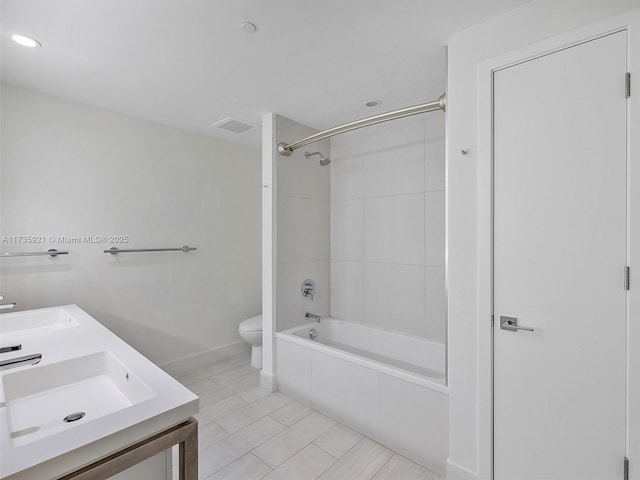 full bathroom featuring vanity, tiled shower / bath, and toilet