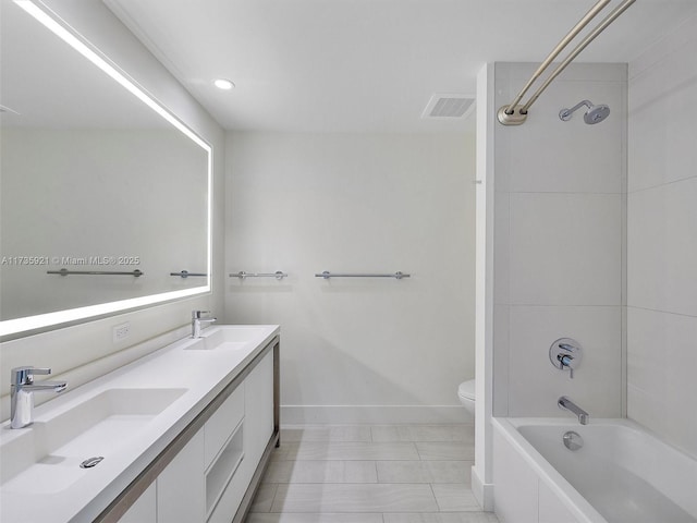 full bathroom with tiled shower / bath, vanity, and toilet