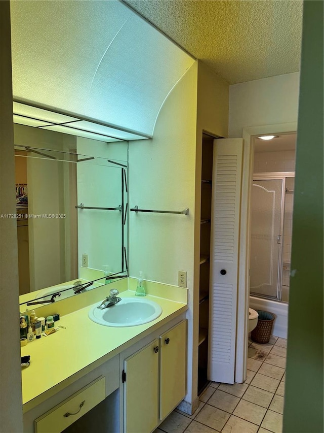 bathroom featuring vanity, tile patterned flooring, and a textured ceiling