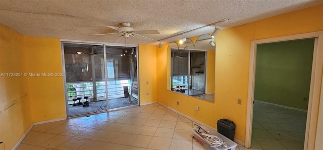 spare room featuring ceiling fan, rail lighting, light tile patterned floors, and a textured ceiling