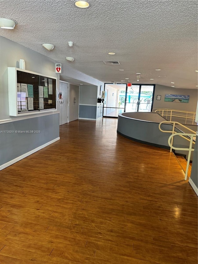 interior space featuring wood-type flooring and a textured ceiling