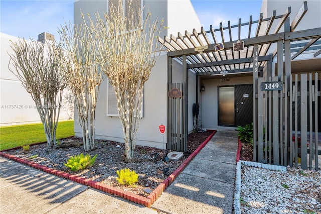 view of exterior entry featuring a pergola