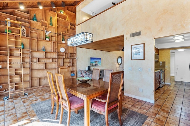 dining room with beam ceiling, ceiling fan, and high vaulted ceiling